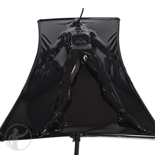 A person is fully encased in a black latex vacuum suit.