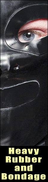 A close-up view of a person wearing a heavy black rubber hood with eye cutouts revealing a blue eye.