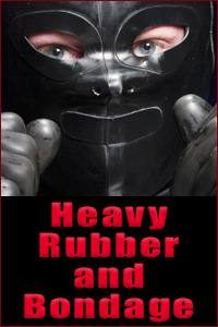 A close-up portrait of a person wearing a black rubber hood and gloves with red text reading Heavy Rubber and Bondage below.